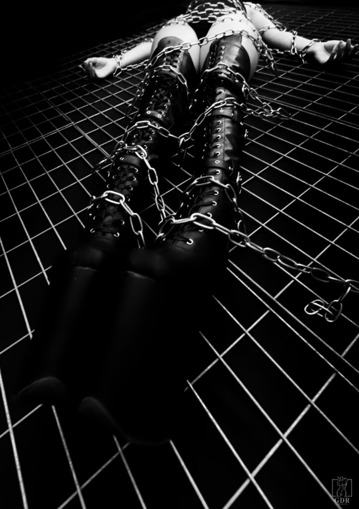 Photographie artistique en noir et blanc d’une femme enchaînée, symbole de puissance et de liberté — série Liberté enchaînée, GDR Paris.