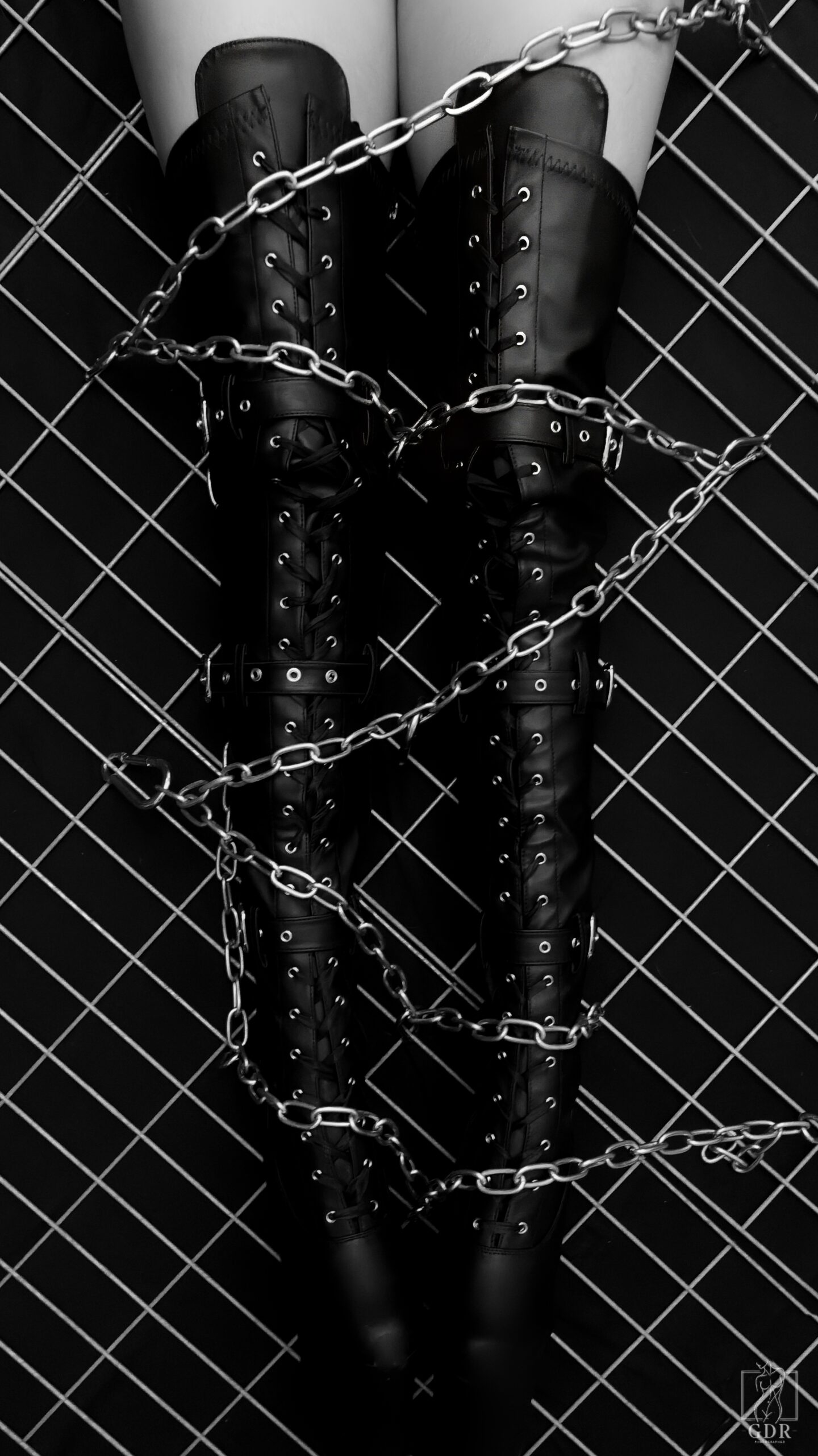 Photographie artistique en noir et blanc d’une femme enchaînée, symbole de puissance et de liberté — série Liberté enchaînée, GDR Paris.